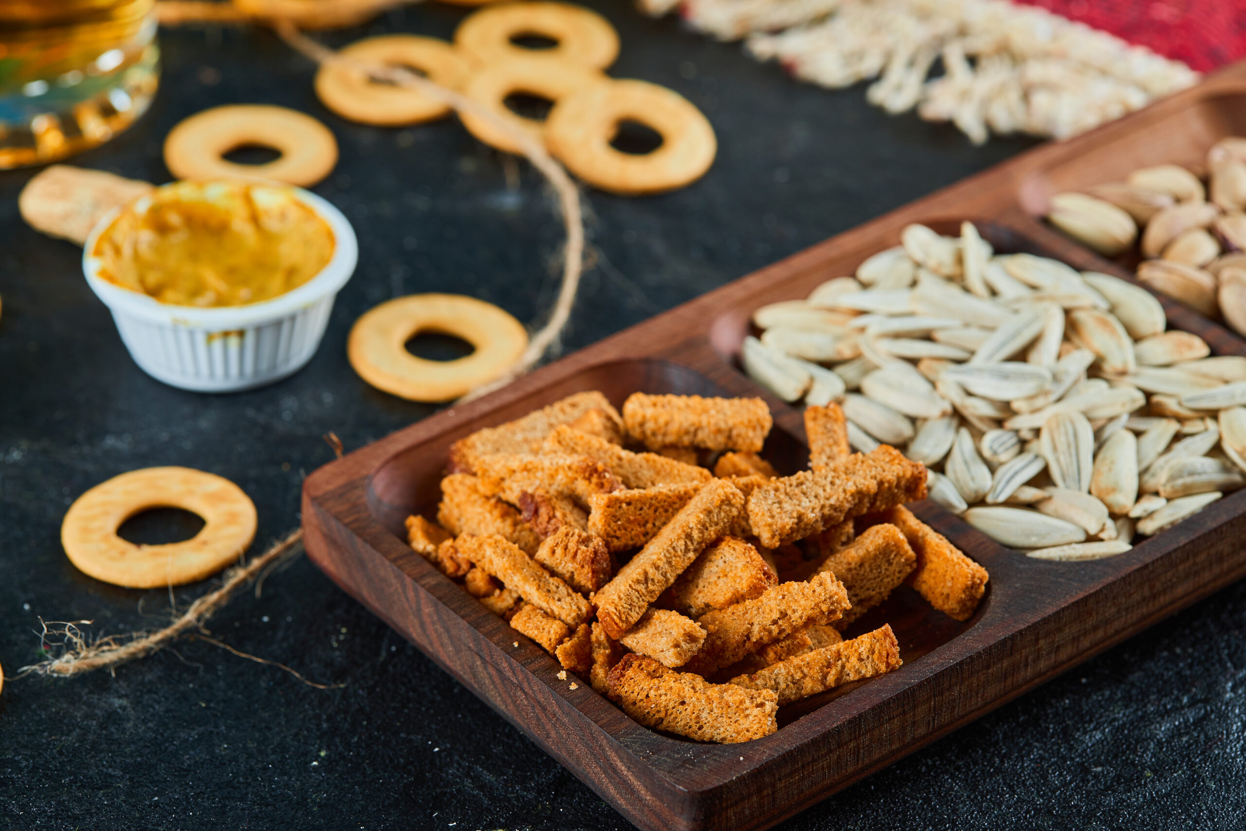 Plate of assorted snacks and crackers on dark table. High quality photo